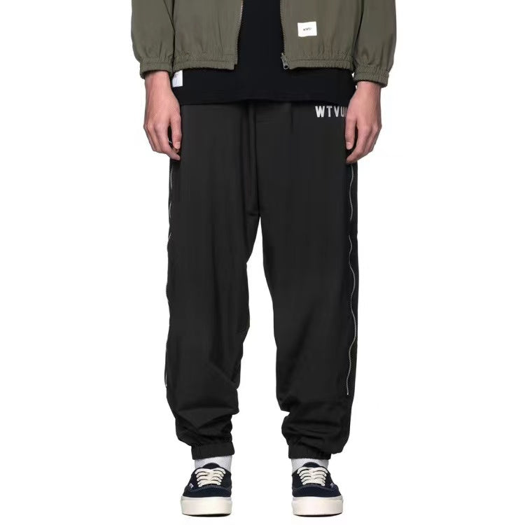 WTAPS pantalon en nylon de style décontracté décoré à fermeture à glissière latérale